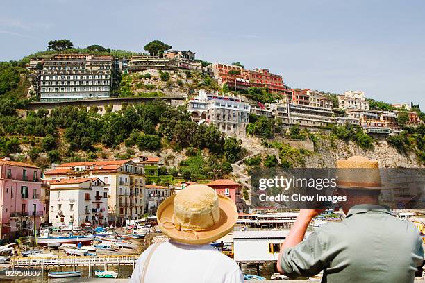 rear view of tourists photographing a harbor, marina grande, capri, sorrento, sorrentine peninsula, naples province, campania, italy - sorrento imagens e fotografias de stock