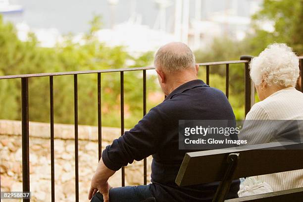 rear view of a couple sitting on the bench, vieux port, cote d'azur, cannes, provence-alpes-cote d'azur, france - couple de vieux stockfoto's en -beelden