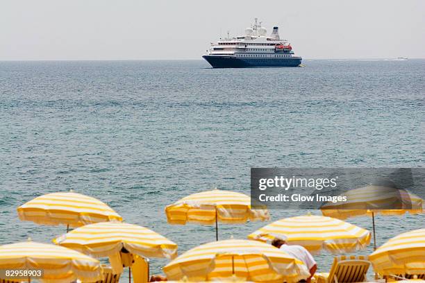 ferry in the sea, plage de la croisette, cote d'azur, cannes, provence-alpes-cote d'azur, france - parasol de plage fotografías e imágenes de stock