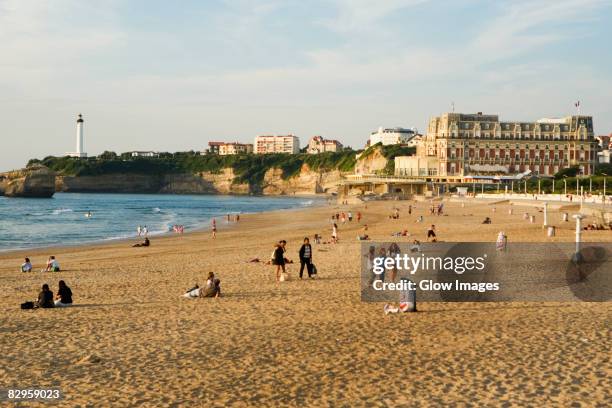 tourists on the beach, phare de biarritz, hotel du palais, grande plage, biarritz, france - biarritz stock pictures, royalty-free photos & images