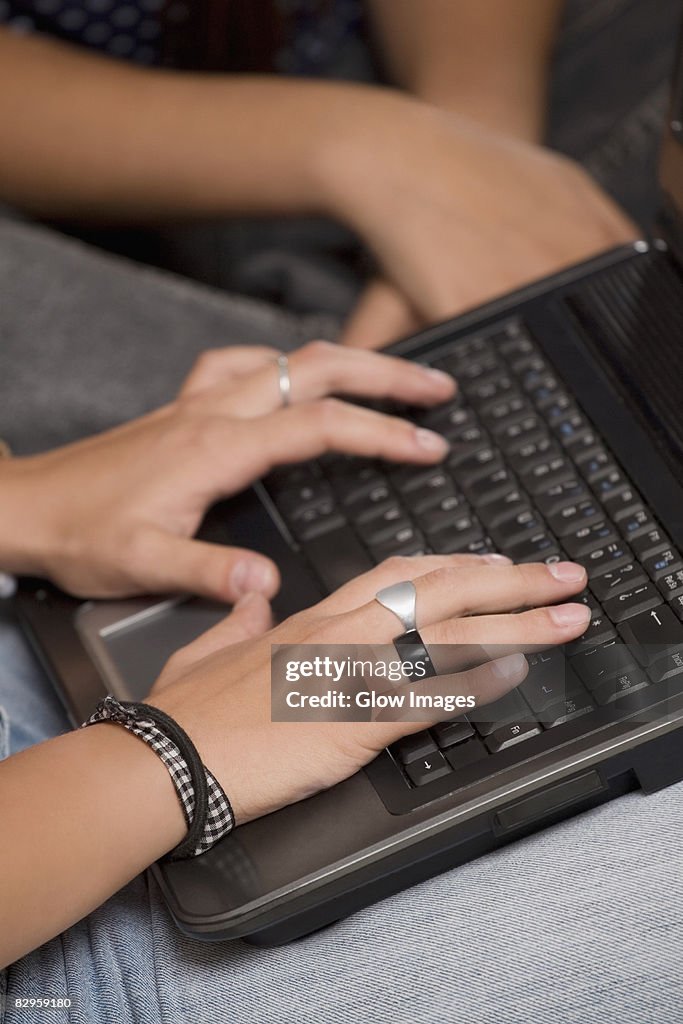 Close-up of a person's hands using a laptop