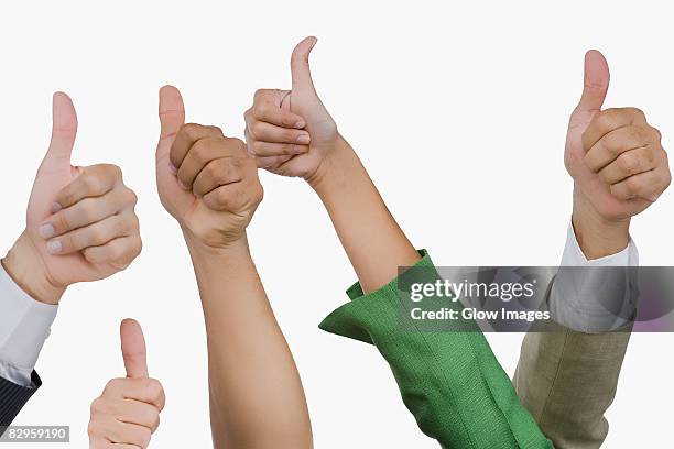 close-up of business executives showing thumbs up sign - puño manga fotografías e imágenes de stock