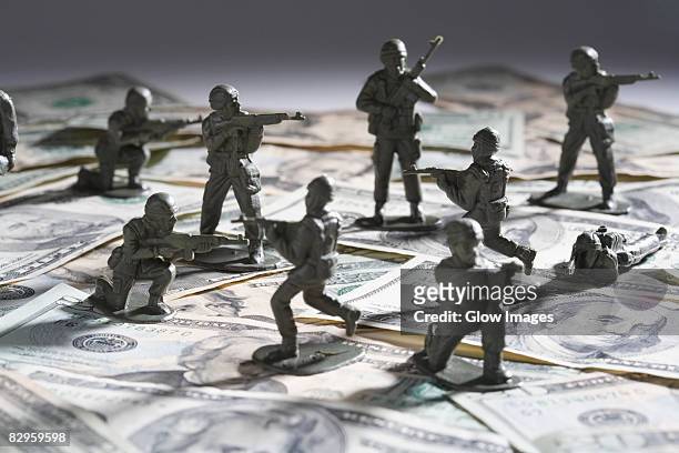 close-up of plastic toys fighting on paper currency - army soldier toy - fotografias e filmes do acervo