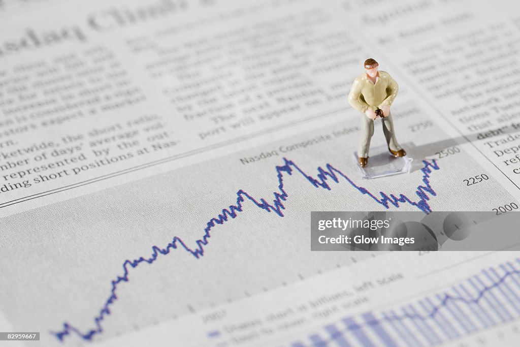 Figurine of a businessman standing on a financial newspaper