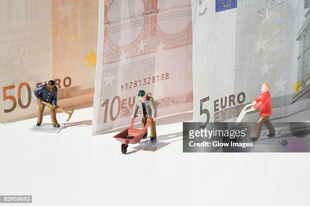 figurines of manual workers with european union banknotes - income stock pictures, royalty-free photos & images