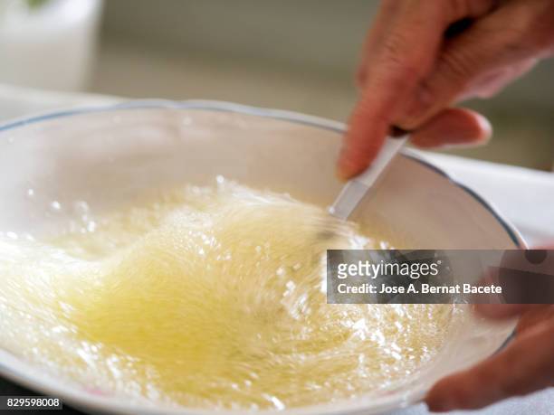 hands of a woman beating eggs on a plate for the preparation of a spanish omelette, spain - female whipping - fotografias e filmes do acervo