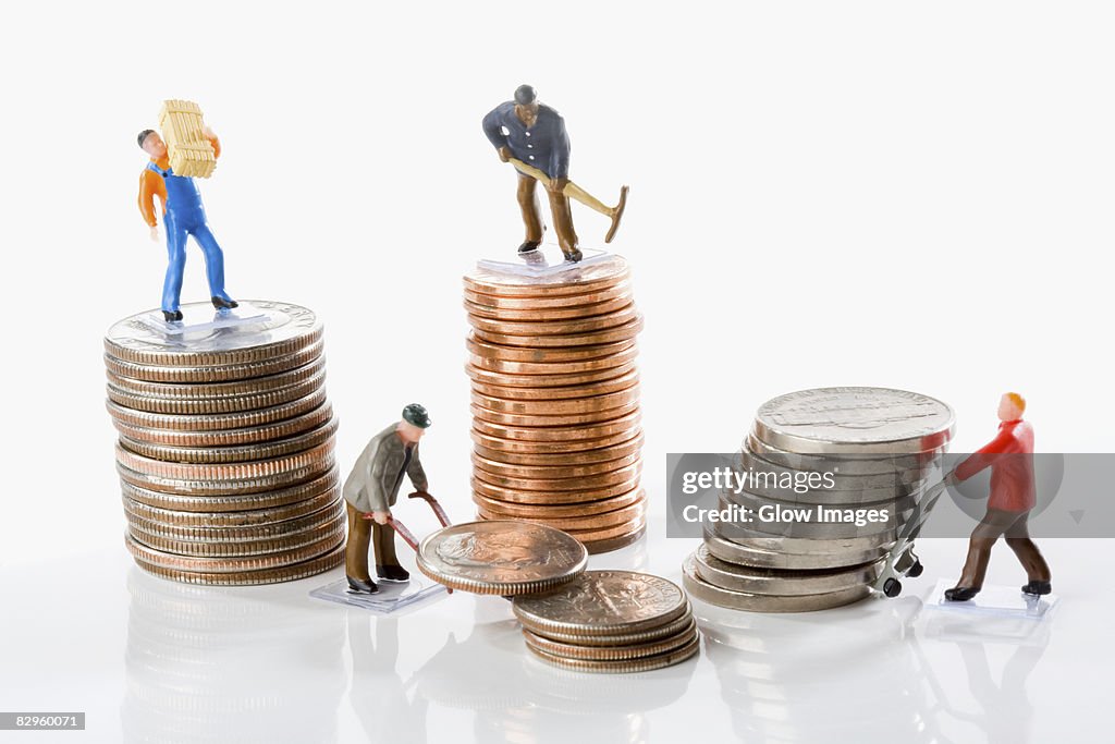 Figurines of manual workers with stacks of coins