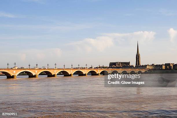 arch bridge across a river, pont de pierre, st. michel basilica, garonne river, bordeaux, aquitaine, france - garonne stock pictures, royalty-free photos & images