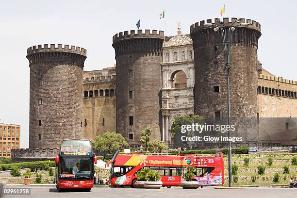 buses in front of a castle, castel nuovo, naples, naples province, campania, italy - maschio angioino stock pictures, royalty-free photos & images