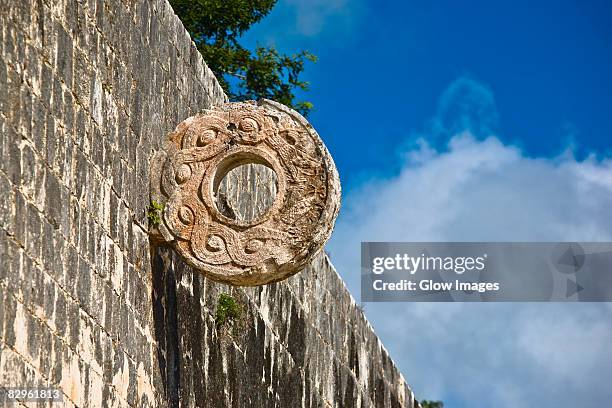 circular carved stone on the wall, ball court ring, chichen itza, yucatan, mexico - chichen itza stockfoto's en -beelden