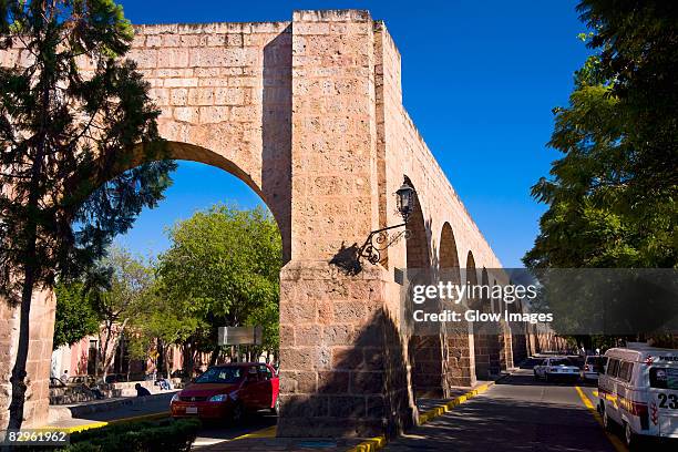 ruins of an aqueduct at the roadside, morelia, michoacan state, mexico - acueducto stock pictures, royalty-free photos & images