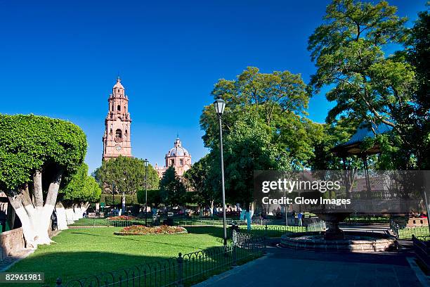 park with a cathedral in the background, morelia cathedral, plaza de los martires, morelia, michoacan state, mexico - morélia imagens e fotografias de stock