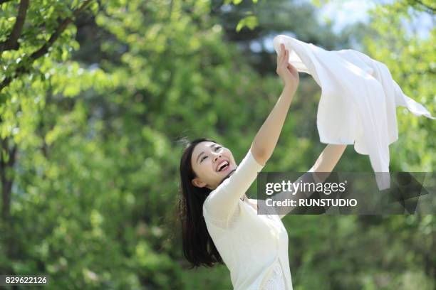 a woman spreading out laundry - beautiful women spreading stock-fotos und bilder