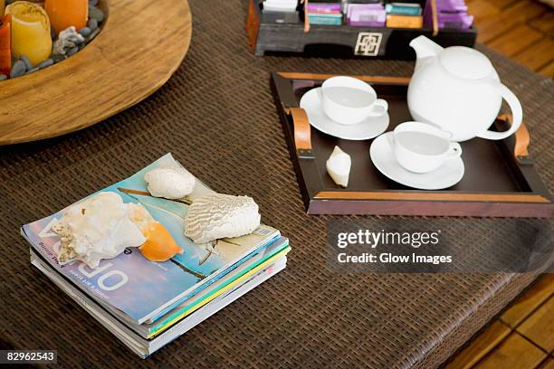 high angle view of a serving tray and magazines on a table - mesa baja de salón fotografías e imágenes de stock