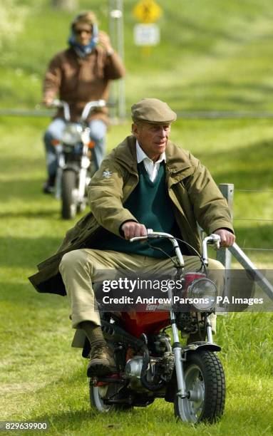 The Duke Of Edinburgh and Lady Penny Romsey ride mini motorbikes as they check out the cross-country carriage course.