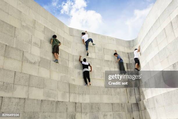 five young men climbing the wall - concrete wall stock pictures, royalty-free photos & images