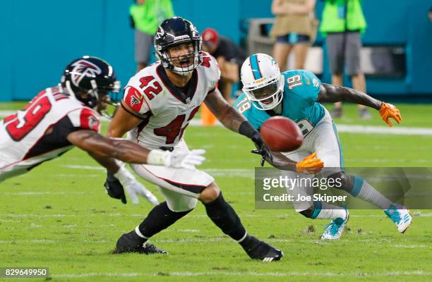 Goodwin of the Atlanta Falcons, left, Duke Riley of the Atlanta Falcons and Jakeem Grant of the Miami Dolphins reach for a loose ball in the first...