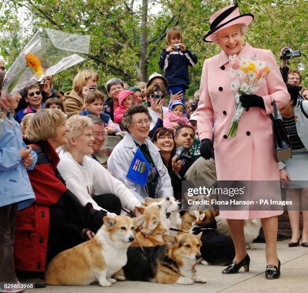 Britain's Queen Elizabeth II is greeted by local corgi enthusiasts as she departs the Legislature Building.