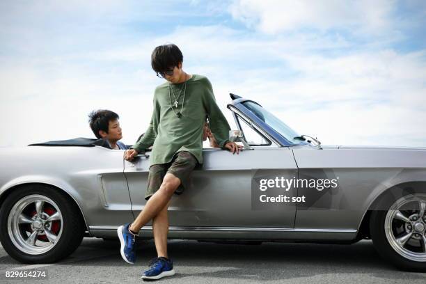 young man portrait with friend in convertible car - 3 guy friends road trip stock pictures, royalty-free photos & images