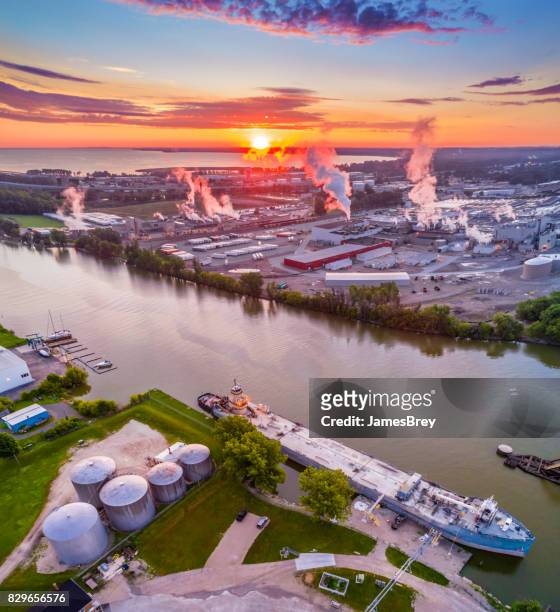 sonnenaufgang über industrielle am flussufer, mit schiff und fabriken, luftbild. - green bay wisconsin stock-fotos und bilder