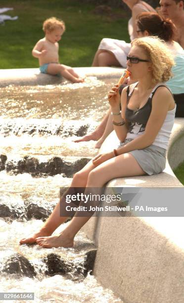 Visitor to the Princess Diana Memorial fountain in Hyde Park, takes the opportunity to cool off her feet in the water, as temperatures soared in the...