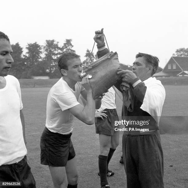 Mexico's Jose Luis Gonzalez takes a long slurp from the water-bag held by trainer Francisco Larios during a break in training