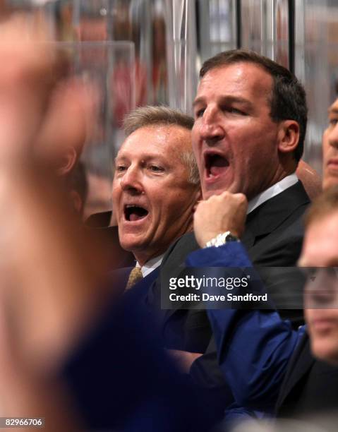Head coach Ron Wilson and assistant coach Tim Hunter of the Toronto Maple Leafs cheer after scoring against the Buffalo Sabres in a preseason NHL...