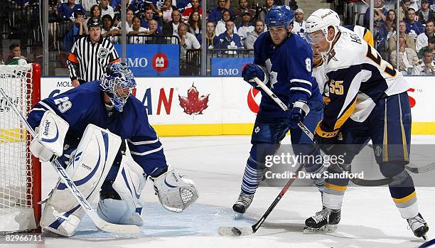 Goaltender Justin Pogge of the Toronto Maple Leafs defends as Jochen Hecht of the Buffalo Sabres tips a shot and Carlo Colaiacovo of the Toronto...