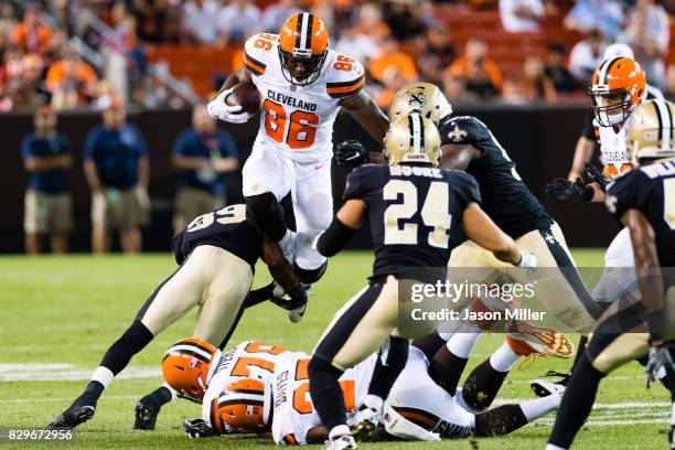 Tight end Randall Telfer of the Cleveland Browns tries to avoid the tackle by jumping over cornerback Taveze Calhoun of the New Orleans Saints during...