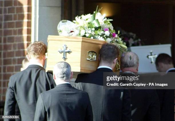 Pall bearers carry coffins at the funeral of a 33-year-old woman and her two young daughters, who were found stabbed to death at their home earlier...