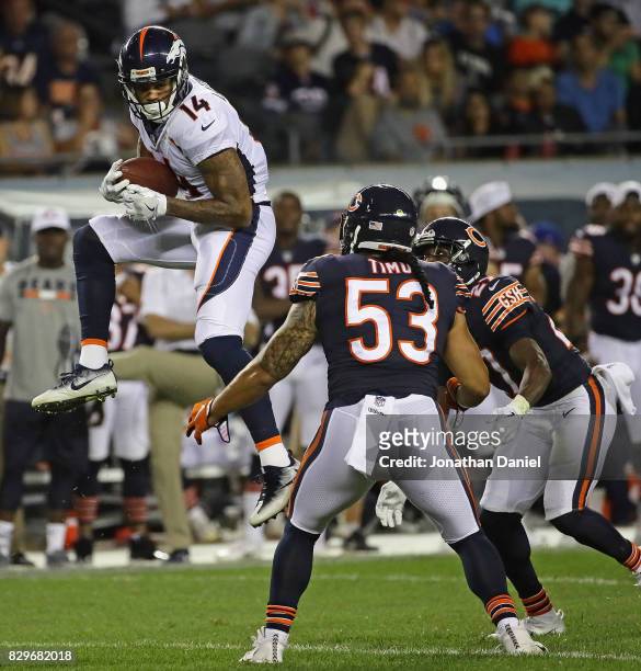 Cody Latimer of the Denver Broncos catches a pass over John Timu and Sherrick McManis of the Chicago Bears during a preseason game at Soldier Field...