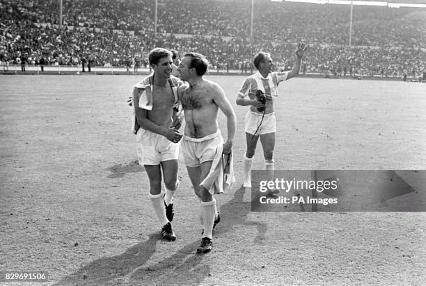 England's Alan Ball and Nobby Stiles celebrate victory as teammate Ray Wilson waves to the crowd