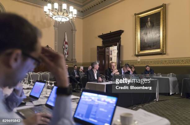 Philip Lowe, governor of the Reserve Bank of Australia , center, speaks during a hearing before the House of Representatives economics committee in...