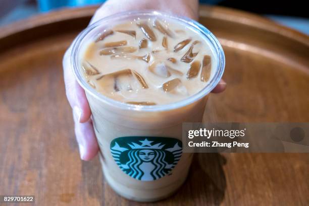 Cup of icy Starbuck coffee. Logo on a cup of Starbuck coffee. Starbucks 2017 Q2 earnings report shows that the profit from China / Asia Pacific grew...
