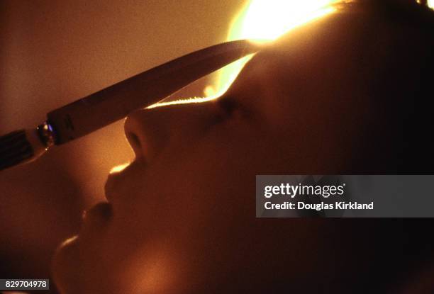 French actress Jeanne Moreau balances a knife on her face, Cuernavaca Mexico, 1965.