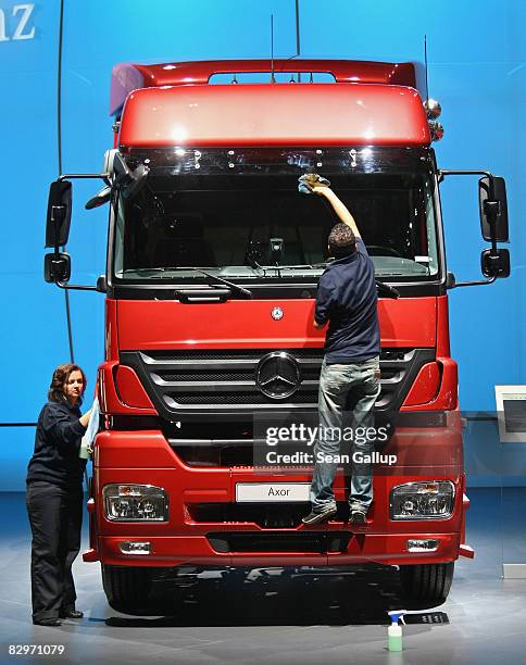 Workers wipe down a heavy truck at the Daimler stand at the IAA commercial vehicles trade fair on September 23, 2008 in Hanover, Germany. The IAA,...