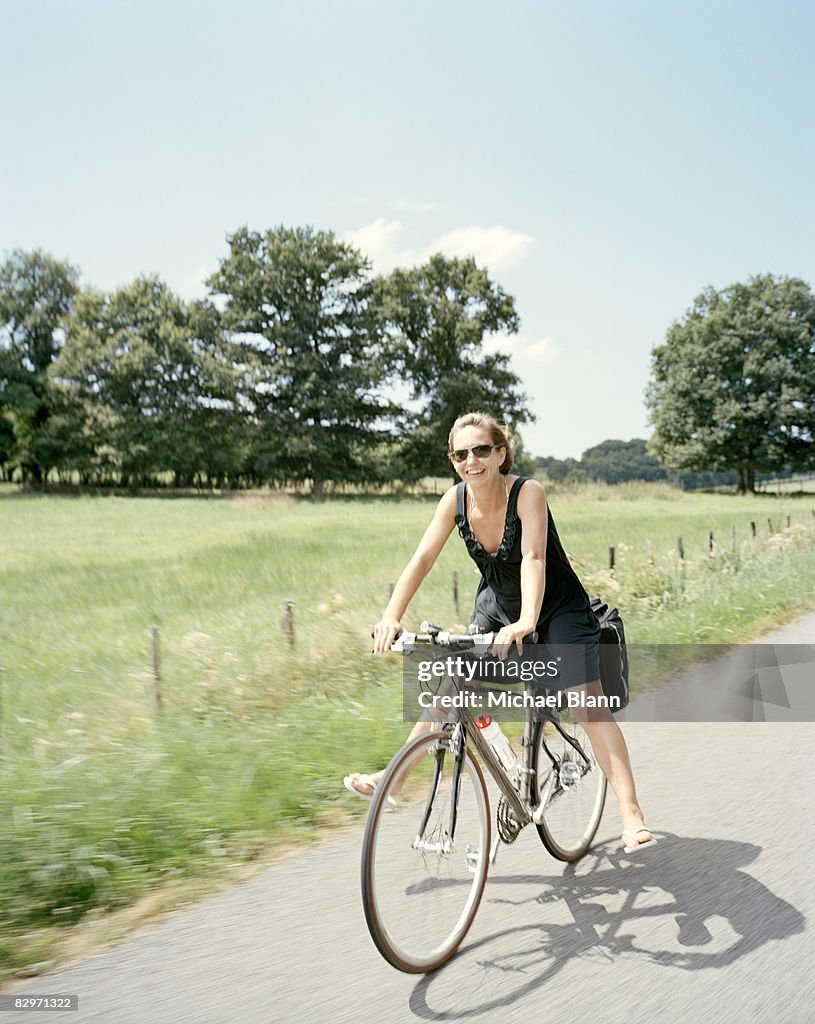 Happy woman smiling riding bike 