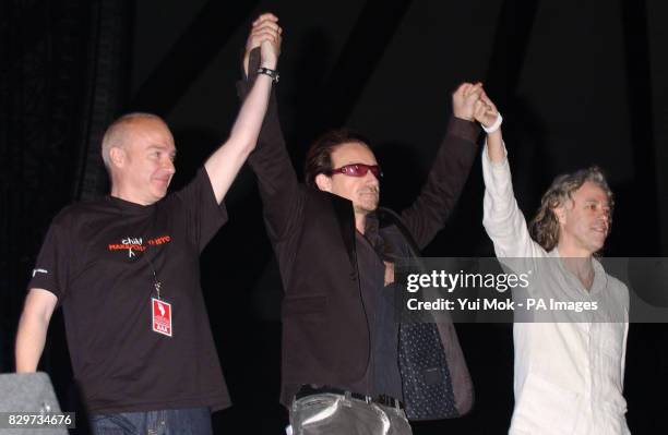 Midge Ure, Bono and Sir Bob Geldof on stage.