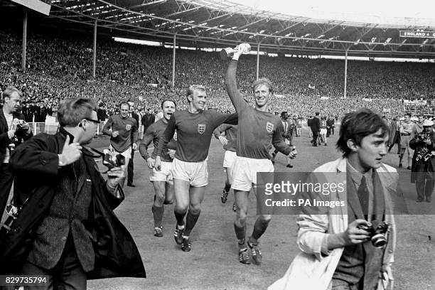England's Jack Charlton holds the Jules Rimet trophy aloft as he parades it around Wembley with teammates Ray Wilson , George Cohen and Bobby Moore...