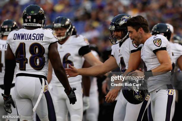 Justin Tucker celebrates with punter Sam Koch of the Baltimore Ravens after a punt against the Washington Redskins in a preseason game at M&T Bank...