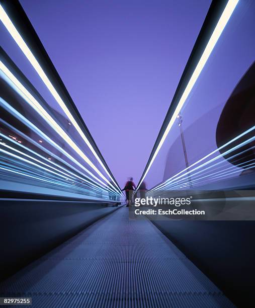 person on a moving escalator in the city. - fluchtpunkt   stadt stock-fotos und bilder