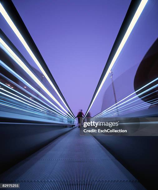 person on a moving escalator in the city. - escalator photos et images de collection