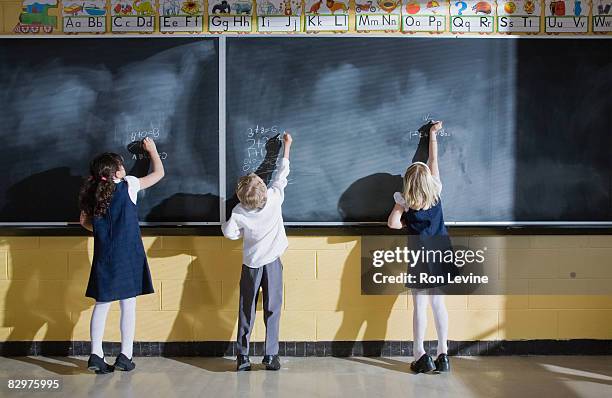 grade 1 students in classroom - blackboard qc stock-fotos und bilder