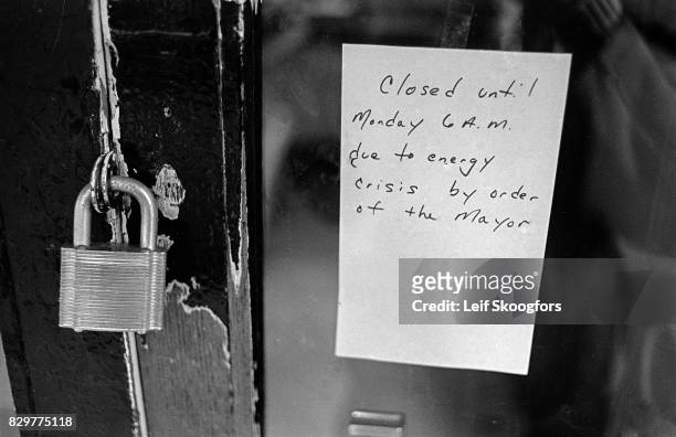 View of a handwritten note on the padlocked door of an unidentified restaurant, Philadelphia, Pennsylvania, July 1973. The sign reads 'Closed unil...