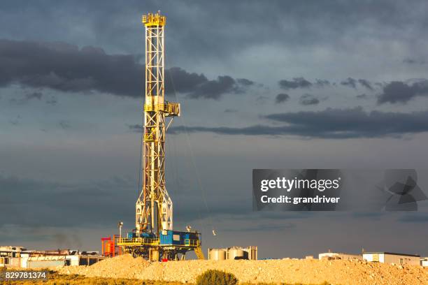 fracturation hydraulique de forage sous un ciel nuageux dramatique - derrick photos et images de collection