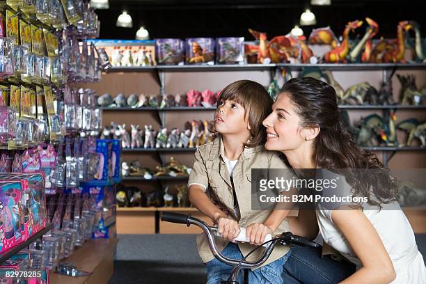 young mother with child (4-5 years) in toy store - loja de brinquedos imagens e fotografias de stock