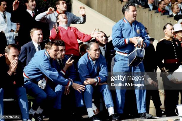 England manager Alf Ramsey looks on impassively as trainers Harold Shepherdson and Les Cocker , and squad members Gerry Byrne , Ian Callaghan and...