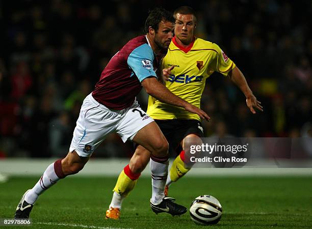 Will Hoskins of Watford chases Lucas Neill of West Ham United during the Third Round Carling Cup match between Watford and West Ham United at...