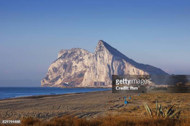 gibraltar rock and the beach of linea de la conception at blue hour - morocco (africa) in the background (spain and gibraltar/ uk) - menai straits stock-fotos und bilder