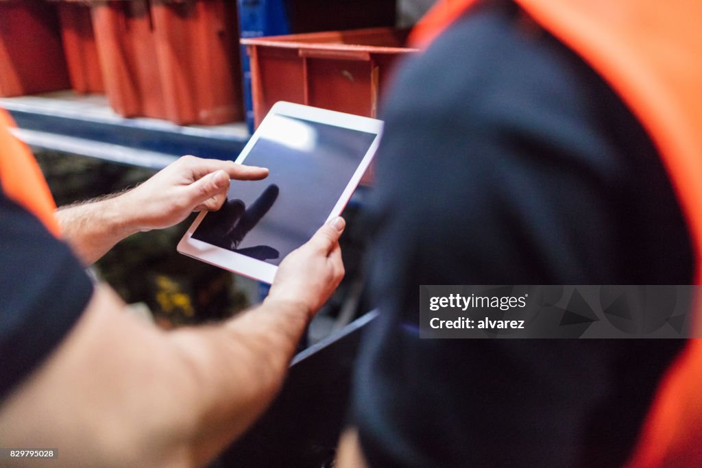 Worker Using Tablet Computer Workers Using Tablet Computer At Factory Warehouse High-Res Stock Photo ...